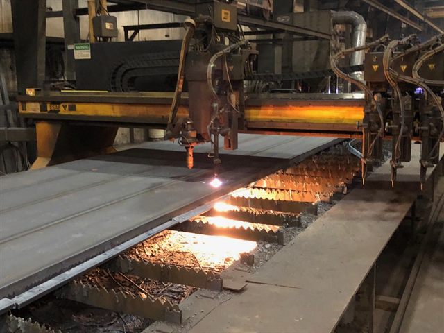 Plasma cutting steel plate in a fabrication shop